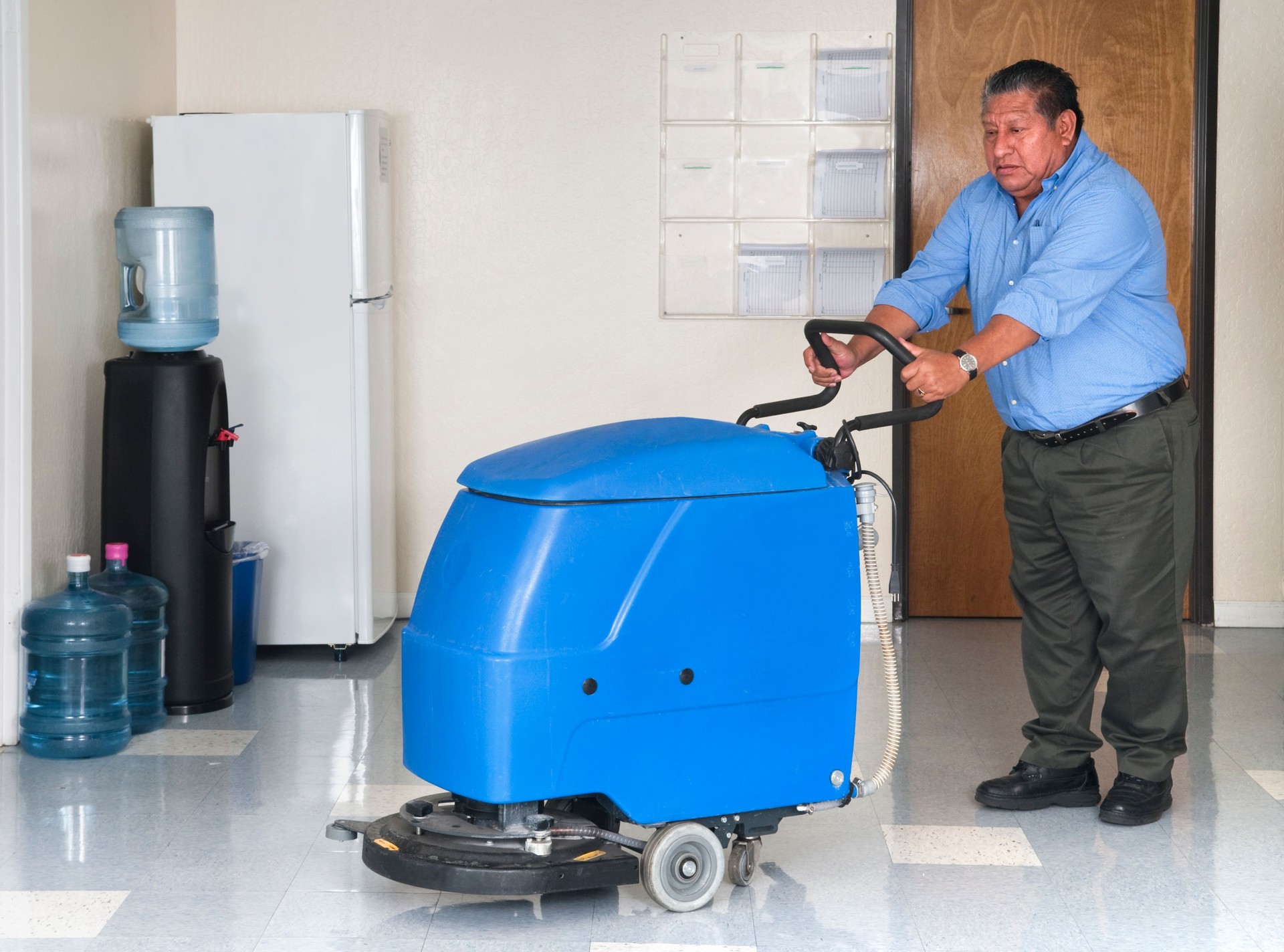 Man using a floor polishing machine in an office